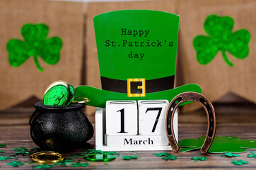 Background for St. Patrick's Day, March 17, with a lucky horseshoe, a leprechaun hat, a clover and...
