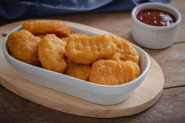 Fried crispy chicken nuggets and ketchup sauce in bowl