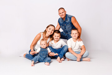 Fototapeta na wymiar beautiful happy young family with three children in denim dress on white background