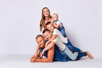 beautiful happy young family with three children in denim dress on white background