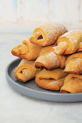 Homemade pastry. The rugelach with apple jam in a gray plate on a table. Traditional Jewish holiday cookie, Bagels, Croissants, Still life photography with cookies.