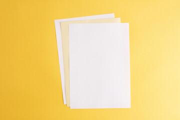 Empty white papers on the yellow background.