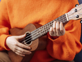 Fototapeta na wymiar Girl playing the ukulele, close-up