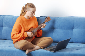 A girl gives a lesson on playing the ukulele online