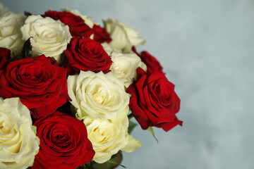 Fototapeta premium Luxury bouquet of fresh roses on light blue background, closeup