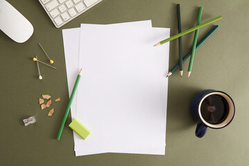 Green pencil, white paper and eraser. Empty place for text or drawing on the green background.