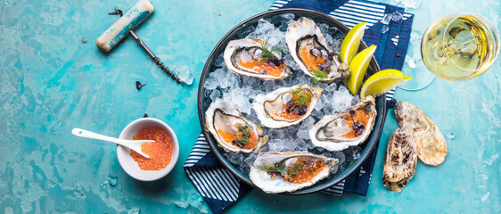 Oysters platter with lemon caviar and ice served on a Blue marine table. - 408085529