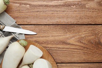 White turnips on wooden table, flat lay. Space for text