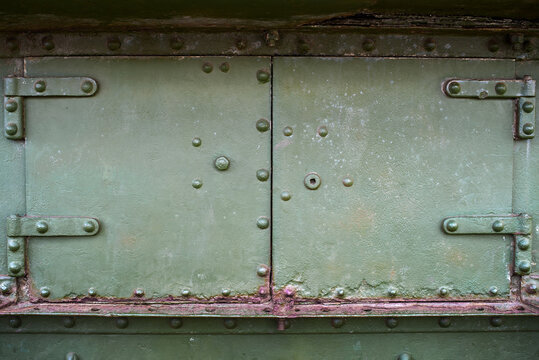 Abstract green metal background with bolts and rivets, copy space. Old painted steel texture, detail of military aircraft. Army, war concept. Top view, flat lay