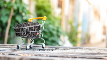 Manure on mini shopping cart with natural light background (Business and finance concept)
