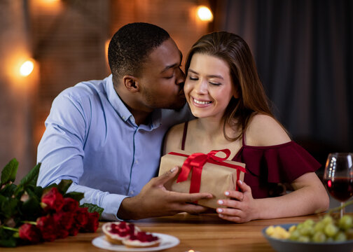 Loving african boyfriend making romantic present for his girlfriend on valentine's day