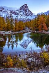 Fototapeta premium Blue Lake and the surroundings area during the fall and changing of the colors. Foliage, reflection and snowy peaks.