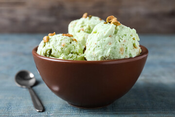 Delicious pistachio ice cream in bowl on table, closeup