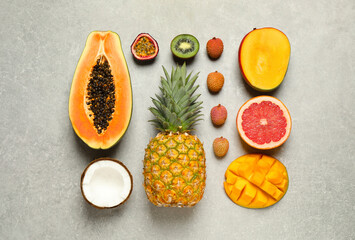 Fresh ripe papaya and other fruits on light grey table, flat lay