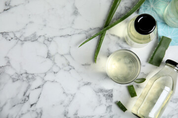 Fototapeta na wymiar Fresh aloe drink and leaves on white marble table, flat lay. Space for text