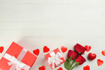 Gift boxes, roses and hearts on white wooden background, flat lay with space for text. Valentine's Day celebration
