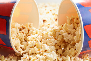 Sweet or salty popcorn scattered from two carton cups.