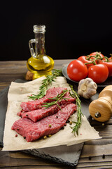Beef steaks close-up on a black background with copy space.
