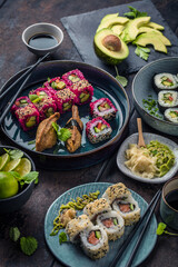 Fototapeta na wymiar japanese sushi food. Maki ands rolls with tuna, salmon, shrimp, crab and avocado. Top view of assorted sushi. Rainbow sushi roll, uramaki, hosomaki and nigiri.