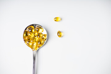 Spoon of omega-3 vitamins on a light background