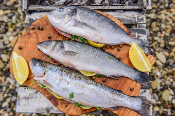 raw fish stuffed with lemon and herbs on the background of the sea