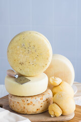 Variety of appetizing cheese heads wheels on wooden board