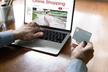 Close up mature man making secure internet payment, holding plastic credit card, typing, entering information, using laptop, elderly customer browsing online shopping website, computer screen, buying