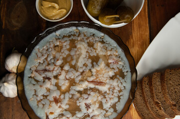Jellied meat on a brown wooden background.Homemade jelly meat with mustard and horseradish on the table. Holodets