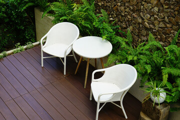 The table and chairs in backyard on stone wall background