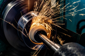 Grinding the end of the workpiece with an abrasive wheel on a circular grinding machine. - obrazy, fototapety, plakaty