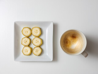 Six Pieces of Sliced Banana on White Square Plate Served with Latte Coffee