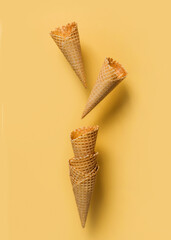 Ice cream cones levitate over yellow background