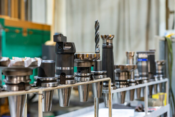 Accessories and tools for a CNC machine on a rack for equipment at a factory and enterprise.