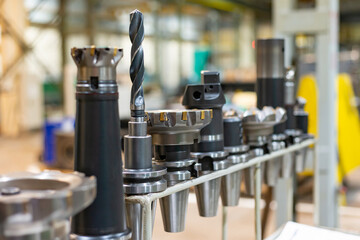Accessories and tools for a CNC machine on a rack for equipment at a factory and enterprise.