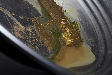 gold nuggets in a metal gold pan