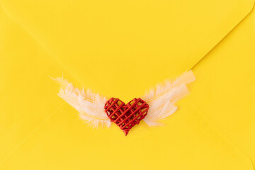Seal make of angel heart with wings.Unique stamp on yellow letter.Minimal love concept ,flat lay.