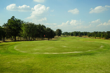 Fototapeta premium Background of evening golf course has sunlight shining down at golf course in Thailand. Nice scenery on a golf course at a late summer afternoon.