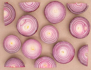 Red onion pattern on sand color background, flat lay vegetables