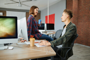 Male and female IT specialists talks in office