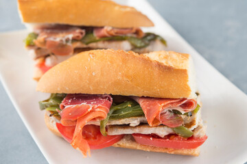 Sandwich Serranito typical in Andalusia with ham, green pepper and grilled pork loin
