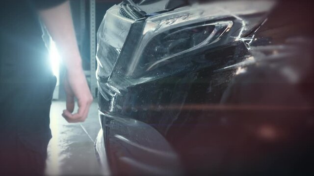 Process of installing of Paint Protection Film or PPF on new car in professional auto Detailing Center. Thin polyurethane film or polymer as protective skin from scratches and rock chips.