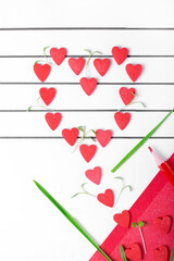 Heart arranged of small hearts flying out of the red envelope on the musical staff. Conceptual photo representing love for music or Valentine's Day