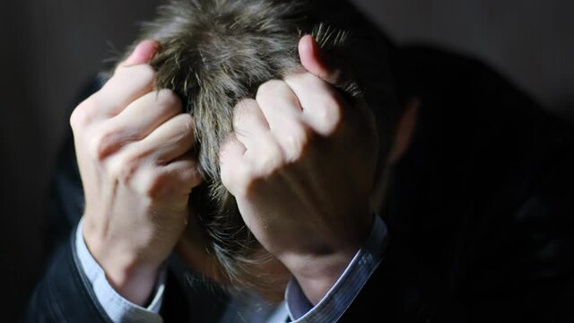 A repentant and annoyed man tears the hair on his head