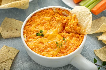 Tuinposter Buffalo chicken dip served with chips and fresh vegetables © fahrwasser