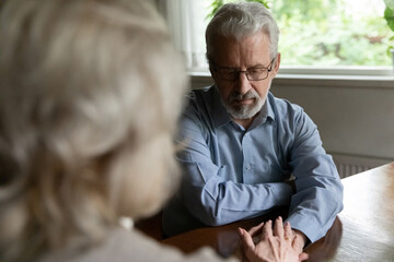 Rear view caring mature wife comforting, supporting frustrated husband, elderly man and woman...