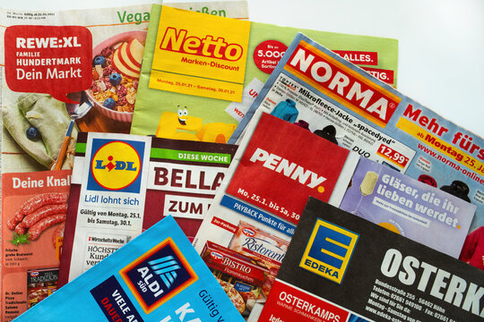 Germany - January 2021: Macro closeup of weekly printed advertising inserts from german discounter companies Lidl, Aldi, Norma, Netto, Penny, Edeka, Rewe
