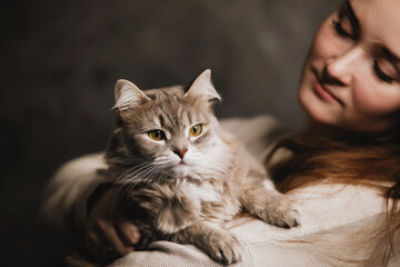 Cat in the arms of a young woman