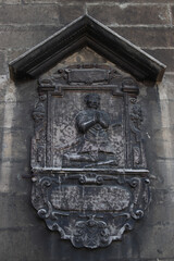 Ancient bas-relief with a praying man. Architectural detail