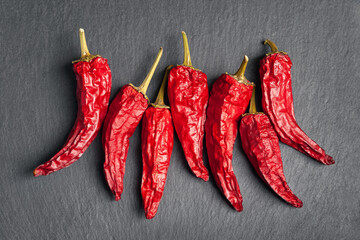 Red pepper. Top view of red dry chili peppers stacked on black shale stone. Hot chili peppers.