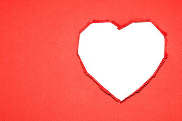 Naklejka na ściany i meble Heart-shaped white hole torn through the red paper. Valentine's Day idea